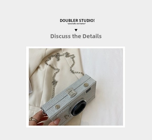Detailed view of camera shaped silver glitter clutch bag with metallic chain strap