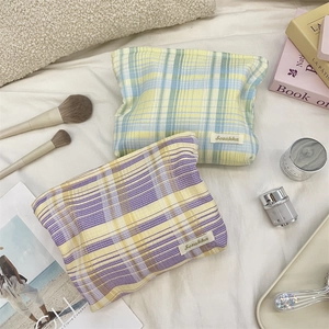 Close-up of colorful checkered cotton makeup bags with Sezakka label on soft fabric