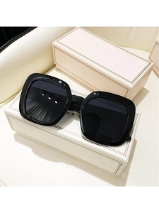 Detailed top view of black oversized square sunglasses with dark lenses and minimalist box