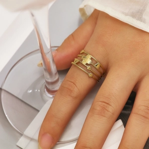 Detailed close-up of a multi-layer gold clover ring worn on a model's finger