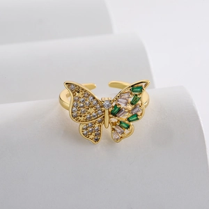 18K gold plated butterfly open ring with green stones and cubic zirconia on a white pedestal
