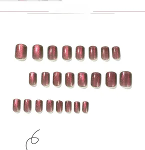 Detailed view of rose pink cat eye press-on nails with glitter finish and varied sizes