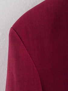 Close-up of wine red plaid blazer fabric texture and precision shoulder stitching