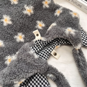 Détail du sac cabas en peluche grise avec doublure à carreaux noirs et blancs et bouton pression