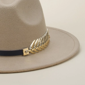 Close-up of golden metal leaf decoration on khaki wool felt fedora hat band