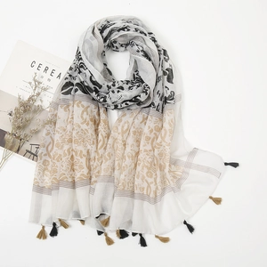 Detail of ethnic floral and leopard print scarf featuring bicolor fringe edge tassels