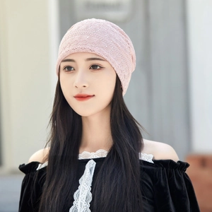 Detailed view of pink lace beanie with delicate hollow patterns and shimmering sequins