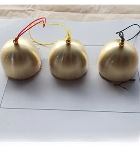 Détail de cloches sphériques en laiton doré mat avec des cordes tressées colorées