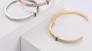 Detailed view of silver, gold, and rose gold geometric bangles with Roman numerals