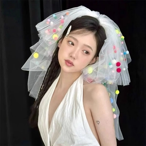 Detail of white mesh wedding veil with colorful pom-poms for festive birthday party looks