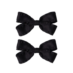 Pair of elegant black bow hair clips with ruffled edges on a clean white background