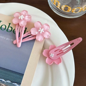 Three sweet pink cherry blossom hair clips for women and children on a minimalist card