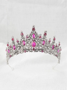 Close-up of silver princess crown featuring pink teardrop gems and clear sparkling rhinestones