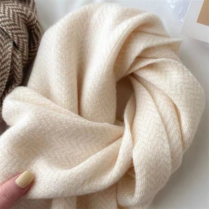 Gros plan d'une écharpe en maille blanc crème avec texture chevrons douce et tissage épais