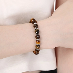 Tiger eye bead bracelet on wrist with silver spacers and natural brown stone textures