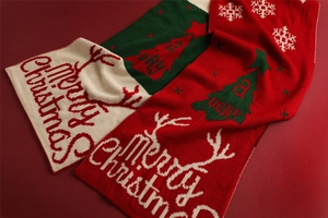 Close-up of knit Christmas scarf featuring reindeer, snowflakes and Merry Christmas text