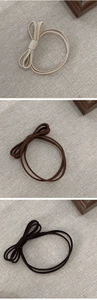 Detailed view of elastic bow hair ties in beige, brown, and black woven fabric set