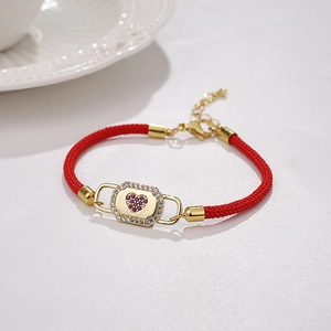 Close-up of red Milan rope bracelet featuring a gold heart lock and purple zircon
