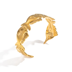 Close-up of polished 18K gold plated fish-shaped open cuff bracelet in high-gloss finish