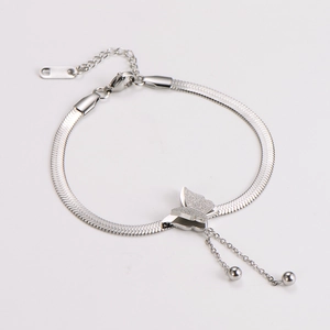 Detailed macro of silver butterfly charm on a snake chain bracelet with adjuster beads