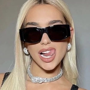 Close-up of black oversized square sunglasses paired with a silver snake jewelry set