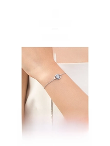 Detail showing an adjustable sterling silver evil eye bracelet with blue zircon inlay