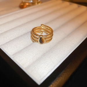 Close-up of gold multi-band ring with pear-shaped brown stone and beaded edge trim