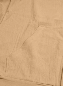 Macro detail of button-down shirt pocket showing durable double-needle stitching and linen texture