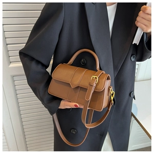 Close-up of brown PU leather small square bag with adjustable strap and golden hardware