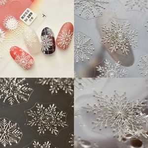 Macro detail of 3D embossed snowflake nail art stickers with intricate white and silver textures