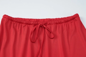 Detail of red elastic waist with drawstring bow and smooth fabric on slim fit skirt