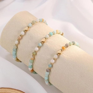 Detailed view of three Amazonite beaded bracelets with heart charms on display stand