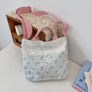 Floral canvas tote bag with white lace embroidery detail and pink adjustable shoulder strap