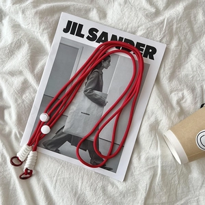 Adjustable red braided nylon crossbody bag strap with metal rings on white aesthetic background