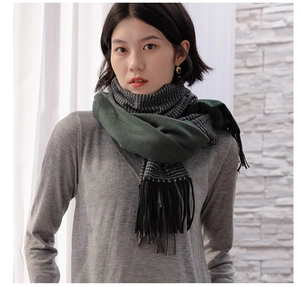 Detail of soft gradient scarf featuring dark green and black houndstooth pattern with tassels