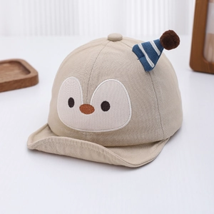 Detail of baby penguin hat showing soft beige cotton fabric and 3D face embroidery