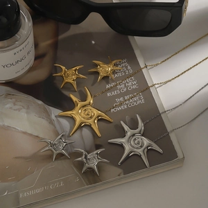Detailed view of irregular starburst jewelry set with sunburst spiral texture on a magazine