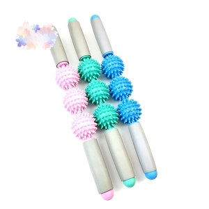 Close-up of portable muscle massage roller stick with three spiked balls for deep tissue relief