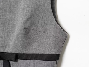 Detail showing grey textured fabric with black satin bow waistbelt for dresses