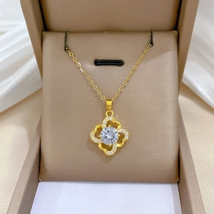Close-up of gold clover pendant with a large central zircon and pavé crystal frame