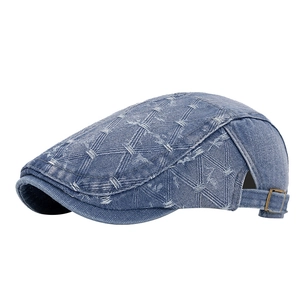 Blue washed denim flat cap with white cross-stitch pattern and brass buckle adjustment