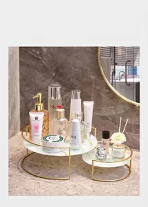 Detalle del organizador de maquillaje dorado de dos niveles con estantes de mármol blanco