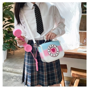 Model showcasing a creative telephone-shaped crossbody bag in a vibrant gradient finish.