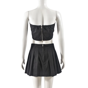 Back view of black two-piece set featuring tube top and pleated skirt with zipper details