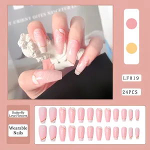 Detail showing pink gradient long coffin press-on nails with white rose and butterfly art