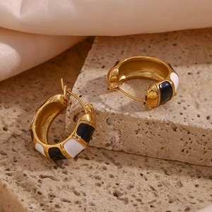 Detail of 18K gold-plated hoop earrings with black and white enamel on natural stone