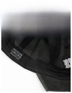 Close-up of black cotton baseball cap interior featuring a 100% cotton label and sweatband