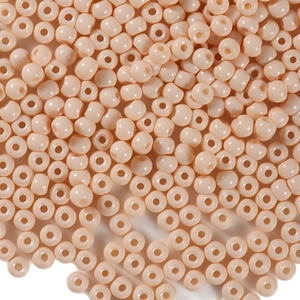 Polished 4mm beige glass seed beads for DIY jewelry making spread on white surface