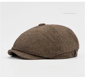 Detailed close-up of khaki herringbone newsboy cap fabric with button and side accents