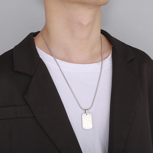 Polished stainless steel military dog tag pendant necklace worn by a male model